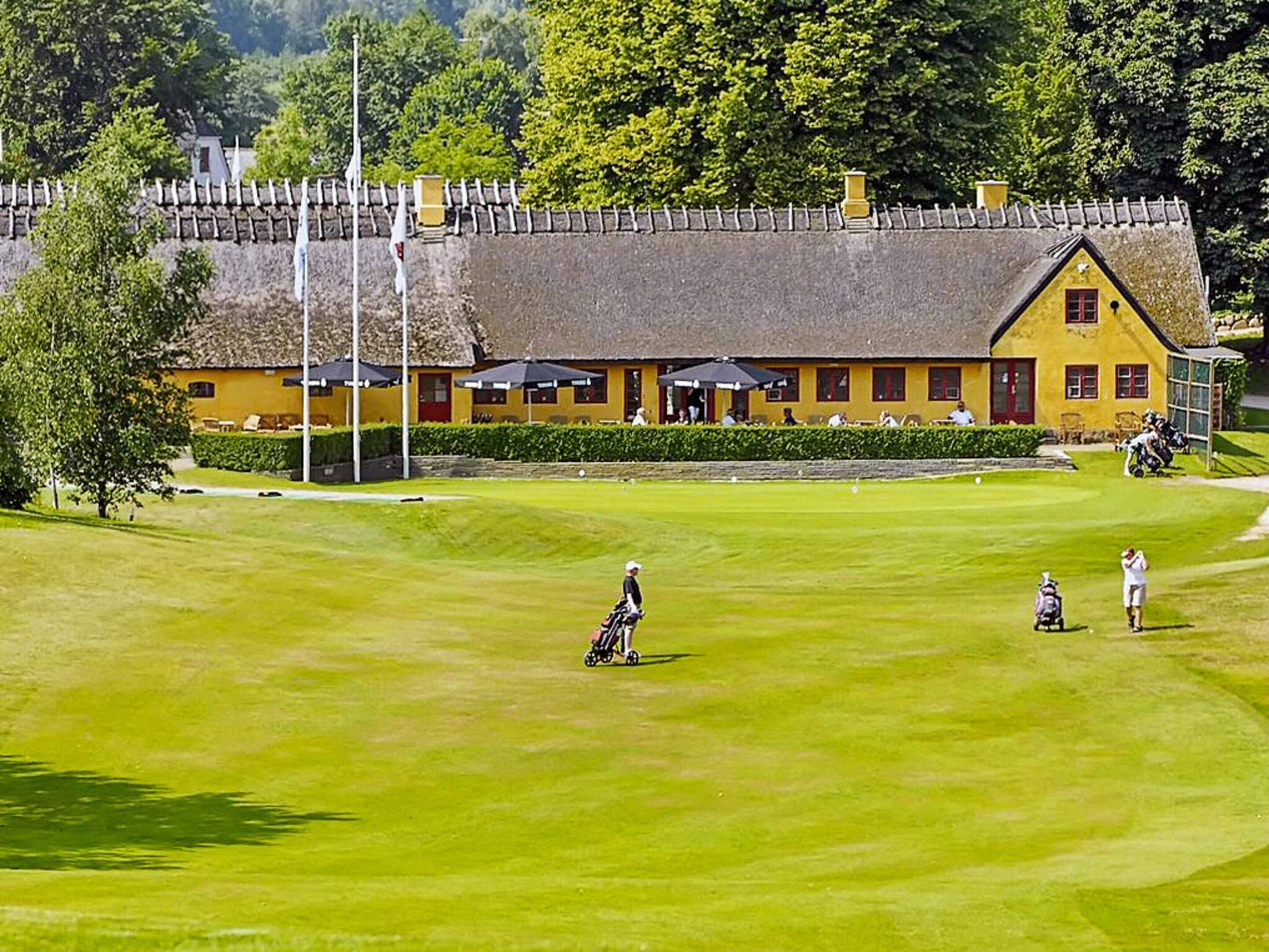 Golfkenttä, jonka taustalla näkyy keltainen rakennus.