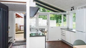 A modern kitchen with a central island, white cabinetry, and a view of the backyard.