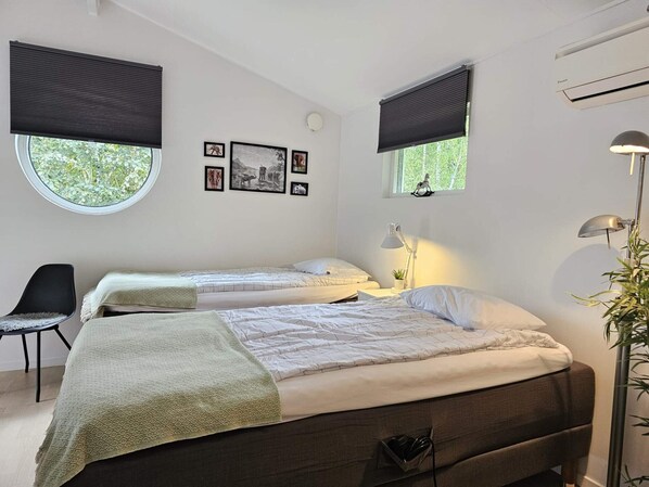 A bedroom with two beds, a desk, a chair, and a window with blinds. - 4 Star Holiday Home in Loddekopinge (Loddekopinge)