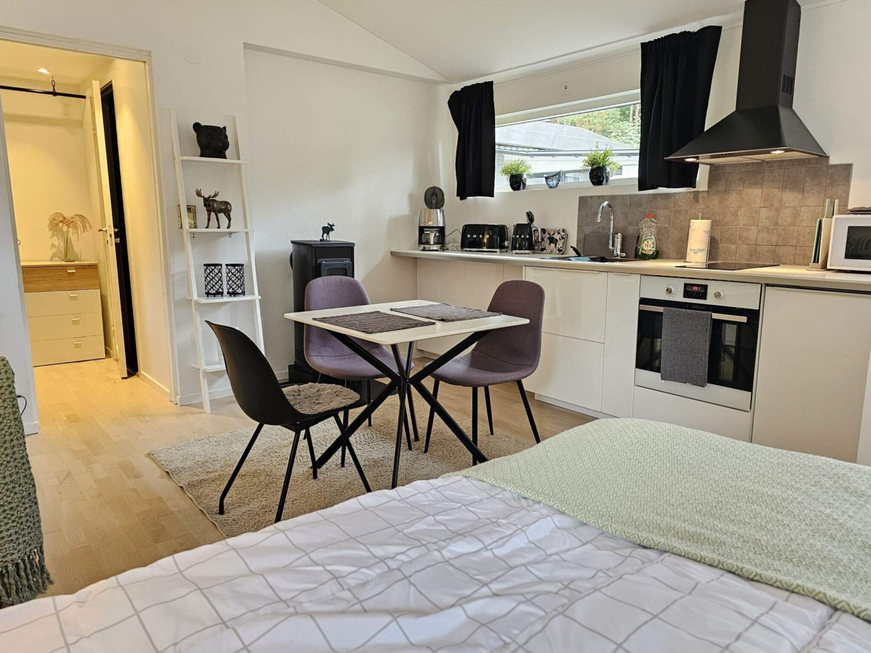 A compact kitchen with a dining area, a bed, and a small living space.