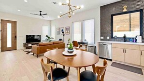 Un salon moderne avec une table à manger en bois, un canapé et un téléviseur.