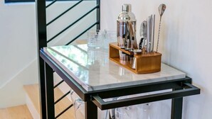 Un comptoir de cuisine avec une machine à café, une verseuse en verre et des ustensiles.