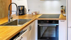 Eine moderne Küche mit Mikrowelle, Kaffeemaschine, Spüle und Backofen.