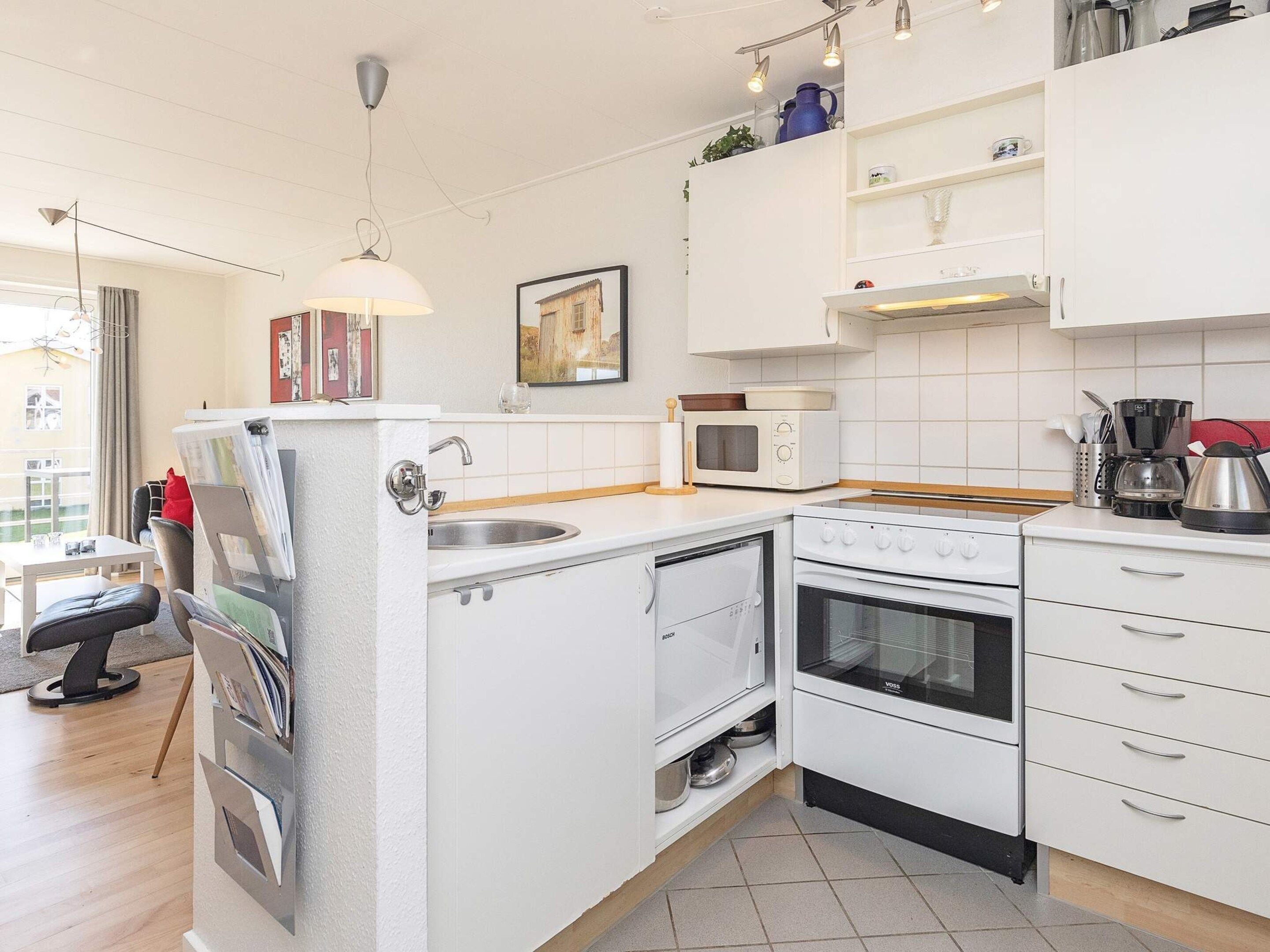 A compact kitchenette with a microwave, oven, and sink.