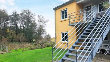 Un edificio amarillo con una escalera metálica que conduce a un balcón.
