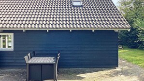 Un bâtiment doté d’un toit recouvert de tuiles et d’un mur extérieur de couleur sombre.