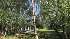Un parc avec des arbres, un espace abrité et un bâtiment en arrière-plan.