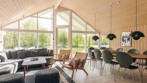 Un vaste espace de vie doté d’une grande fenêtre, d’une table à manger et de meubles modernes.