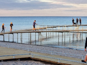 A pier extending into a body of water with people walking on it. - 4 Star Holiday Home in Vaeggerlose (Vaeggerlose)