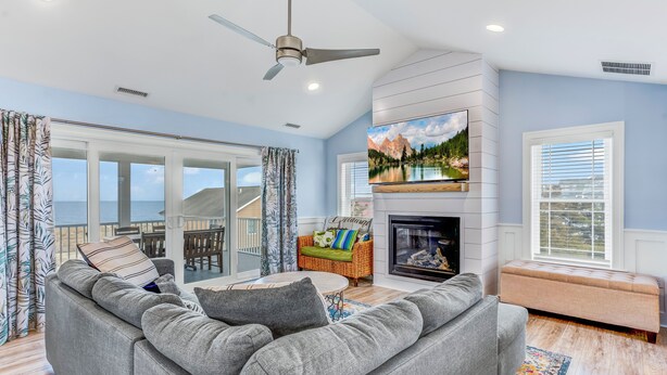 A living room with a grey sofa, a television, a fireplace, and a balcony with a view of the ocean. - Serene Bay View, Steps to Broadkill Beach
Relax and make memories for the books! (Milton)