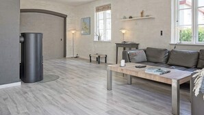 Un salon moderne avec un canapé, une table basse et une cheminée.