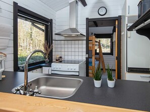 A compact kitchen with a sink, stove, and window. - 4 Person Holiday Home in Nibe (Nibe)
