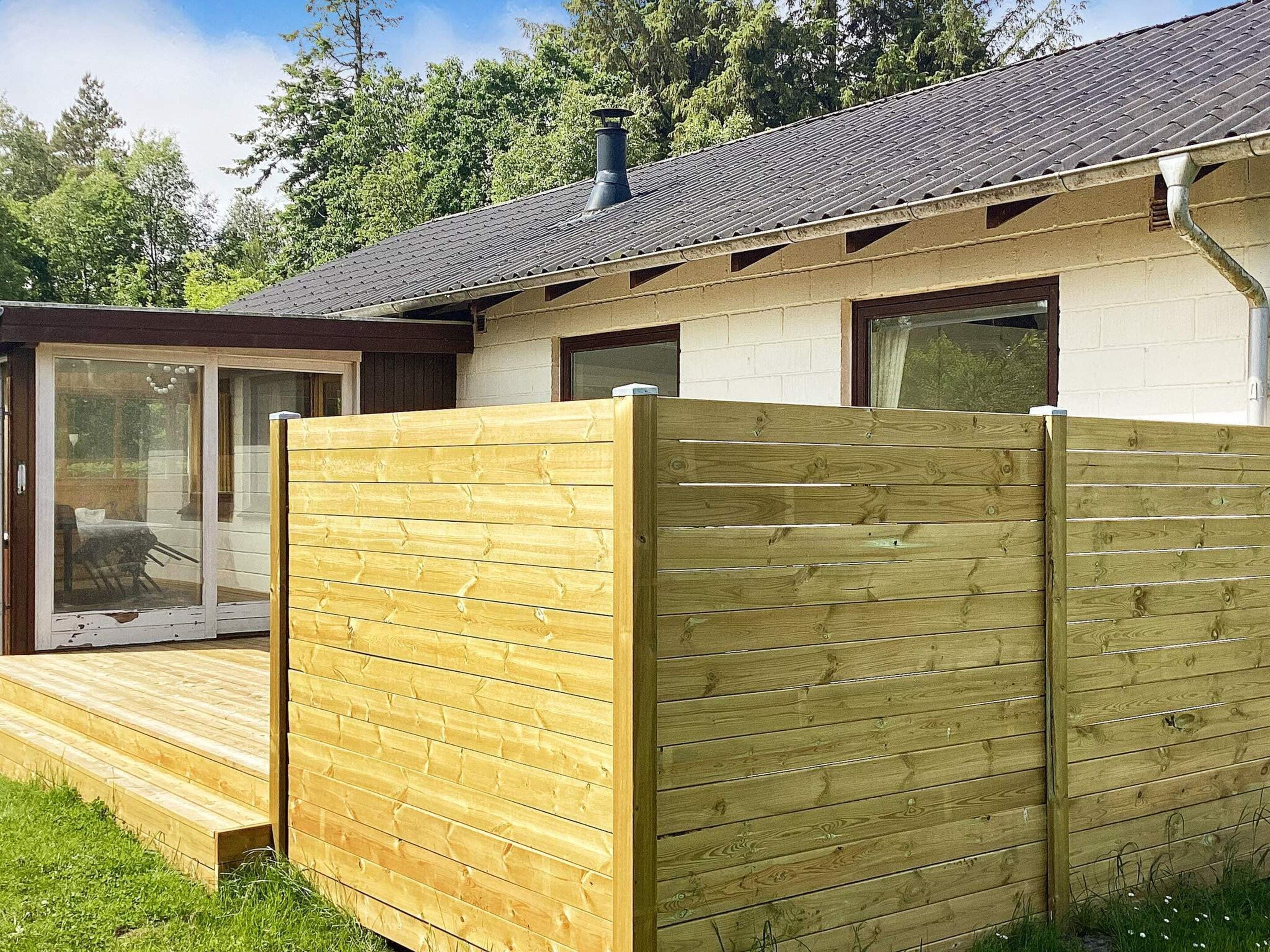 A house with a wooden deck, a sliding glass door, and a chimney.