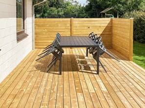 An outdoor wooden deck with a table and chairs, surrounded by a wooden fence. - 6 Person Holiday Home in Norre Nebel (Norre Nebel)