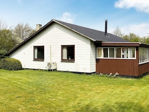 A single-story house with a white exterior and brown trim, featuring two windows and a chimney. - 6 Person Holiday Home in Norre Nebel (Norre Nebel)