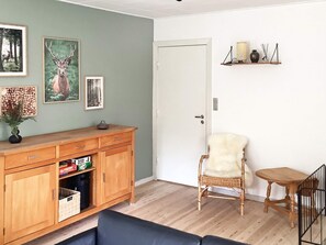 A room with a wooden cabinet, a chair, a small table, and a door. - 6 Person Holiday Home in Norre Nebel (Norre Nebel)