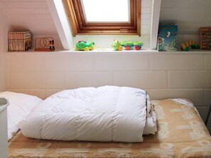 Une chambre à coucher avec un lit, une fenêtre et des jouets sur une étagère.