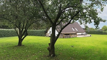A house with a sloped roof, a covered porch, and a well-maintained lawn.