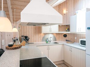 A modern kitchen with a built-in stove, a sink, and wooden cabinets.