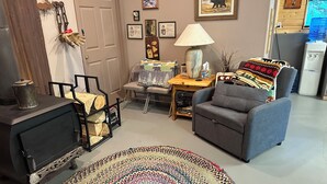 A cozy living room with a fireplace, a sofa, a coffee table, and a rug. - The Shabin at Cardiff Spur (Pierce)