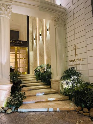 A grand entrance with a marble staircase, columns, and lush greenery. - Maccal Hotel (Xuan Huong - Da Lat)