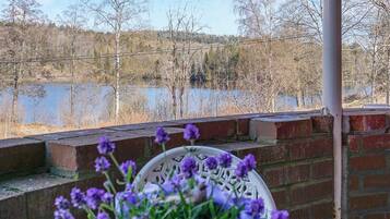 A view from a balcony overlooking a lake with trees and a brick wall.