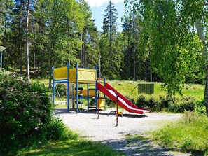 A playground with a slide and climbing structures surrounded by trees. - 4 Star Holiday Home in Ekero (Ekerö)