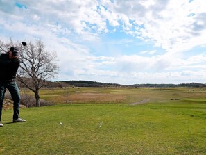 A golf course with a clear sky and a single golfer in the foreground. - 4 Star Holiday Home in Ekero (Ekerö)