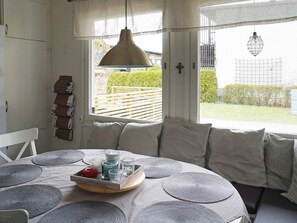 A room with a large window, a bed with a tray of items, and a hanging light fixture. - 4 Star Holiday Home in Ekero (Ekerö)