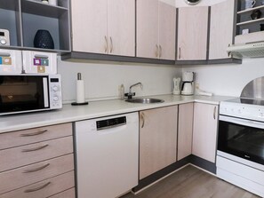 A modern kitchen with white cabinetry, a microwave, a coffee maker, and a dishwasher. - 6 Person Holiday Home in Hadsund (Hadsund)