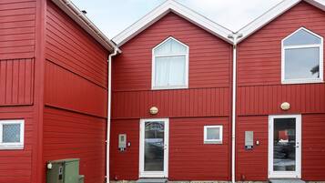 Un edificio rojo con tres puertas y ventanas, con los números 32 y 33.