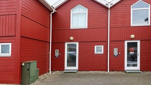 A red building with three doors and windows, numbered 32 and 33. - 6 Person Holiday Home in Hadsund (Hadsund)