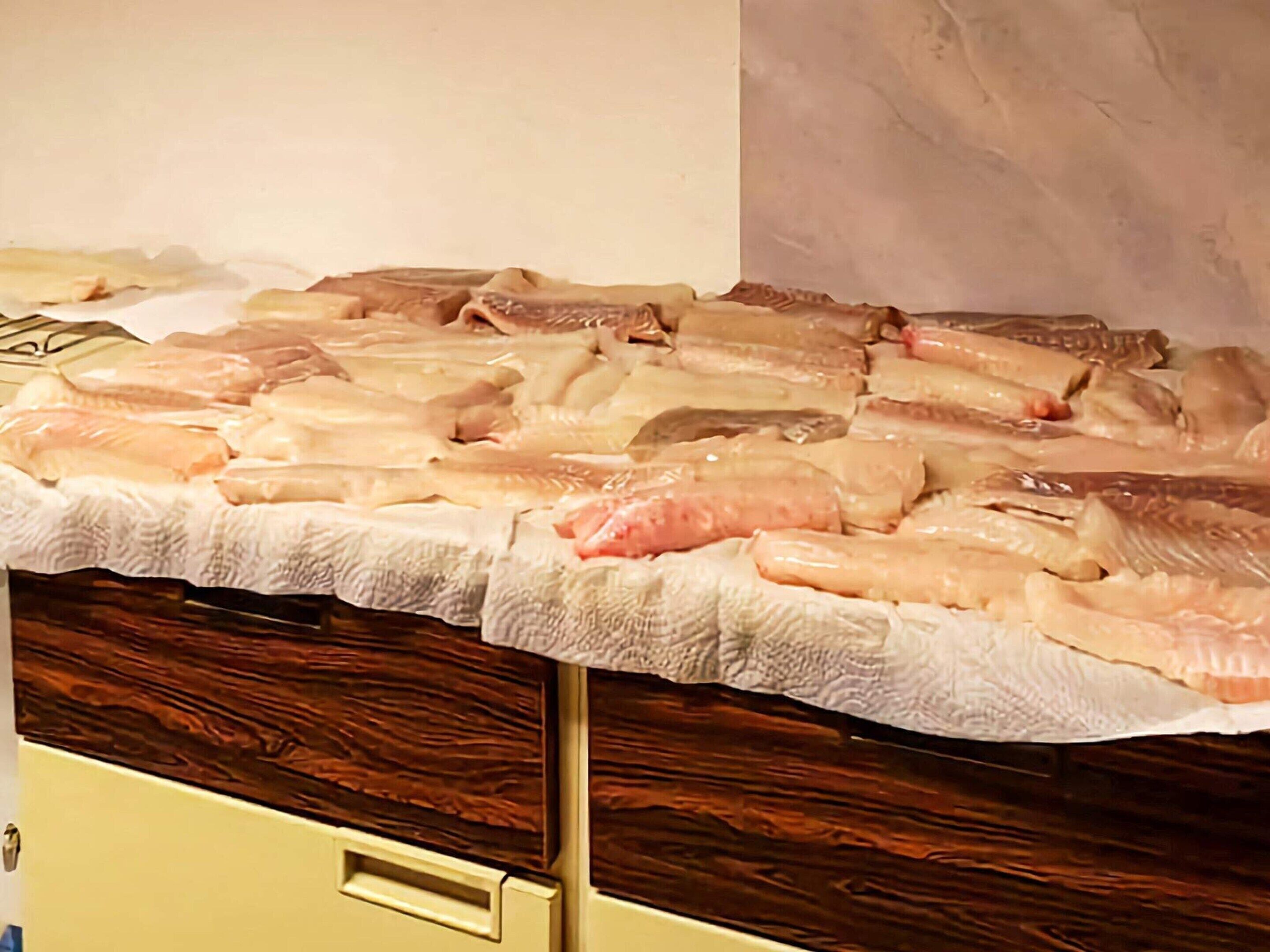 A display of raw fish on a wooden counter.