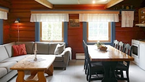 A cozy cabin interior with a wooden dining table, a sofa, and a kitchen area. - 5 Person Holiday Home in Hemsedal (Hemsedal)
