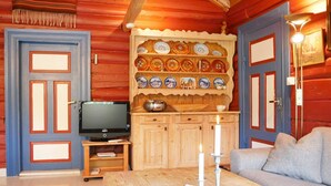 A cozy room with a wooden table, a television, and a wall decorated with plates. - 5 Person Holiday Home in Hemsedal (Hemsedal)