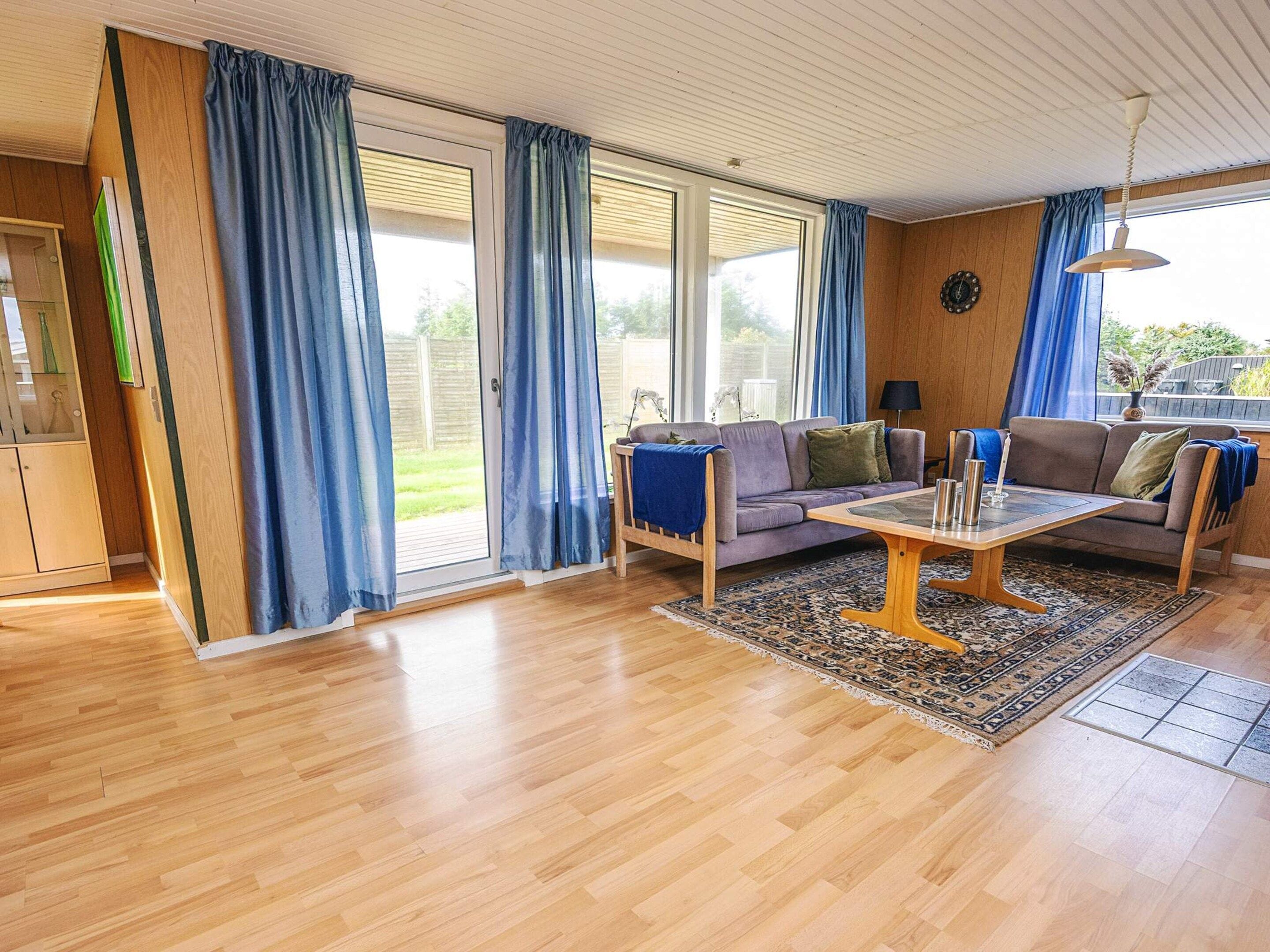 A living room with a sofa, coffee table, and curtains.