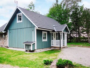 Ein blaues Holzhaus mit Veranda und Steinunterbau.