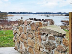 Un mur de pierres offrant une vue sur un lac et une forêt en arrière-plan.