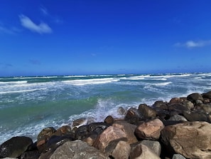 A rocky shoreline with waves crashing against the rocks under a clear blue sky. - 5 Star Holiday Home in Lokken (Lokken)