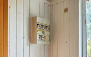 A utility meter box mounted on a wall with a window to the right. - 5 Person Holiday Home in Jaegerspris (Jægerspris)