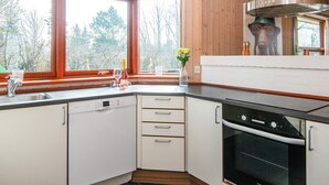 Une cuisine moderne avec des meubles blancs, un lave-vaisselle Bosch et un four Voss.