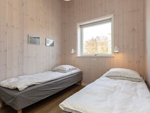 A room with two single beds, a window with a view, and two wall-mounted lamps. - 5 Star Holiday Home in Hadsund (Hadsund)