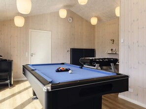A pool table with balls, a foosball table, and a clock on the wall. - 5 Star Holiday Home in Hadsund (Hadsund)