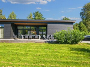 A modern building with a patio area featuring outdoor seating. - 5 Star Holiday Home in Ebeltoft (Ebeltoft)