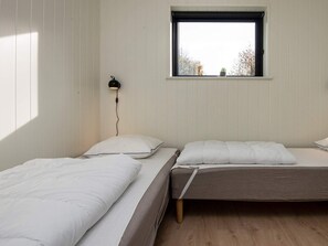 A room with two beds, a window, and a wall-mounted lamp. - 5 Star Holiday Home in Ebeltoft (Ebeltoft)
