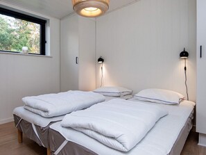 A bedroom with two beds, a window, and two wall-mounted lamps. - 5 Star Holiday Home in Ebeltoft (Ebeltoft)