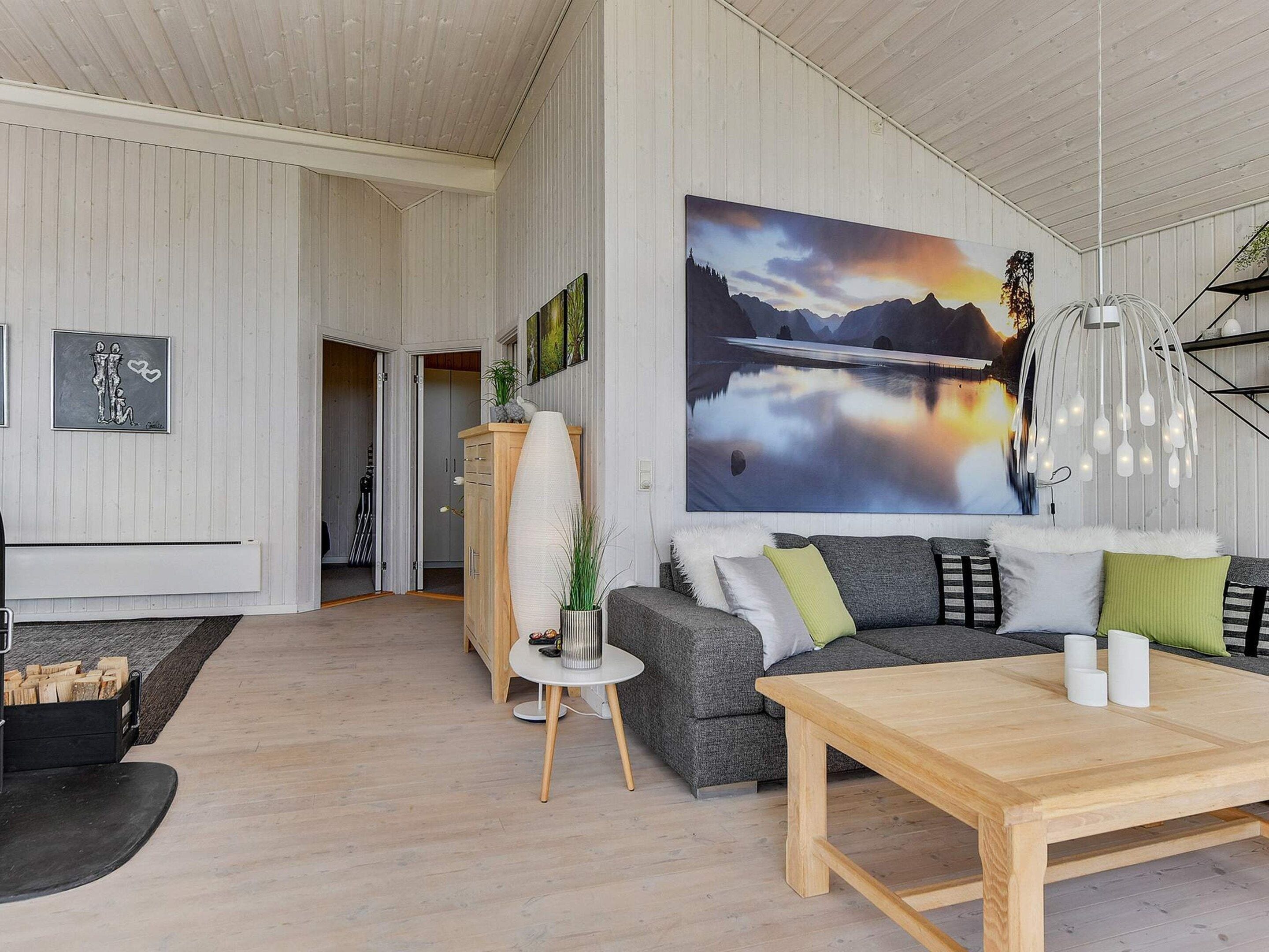 Ein modernes Wohnzimmer mit einem großen Gemälde, einem Holztisch und einem grauen Sofa.
