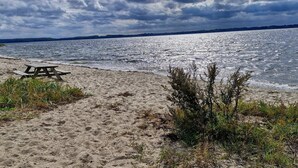 Ein Strand mit einem Picknicktisch und Blick aufs Wasser.
