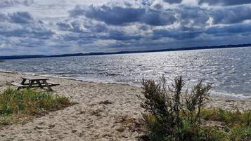 Ein Strand mit einem Picknicktisch und Blick aufs Wasser.