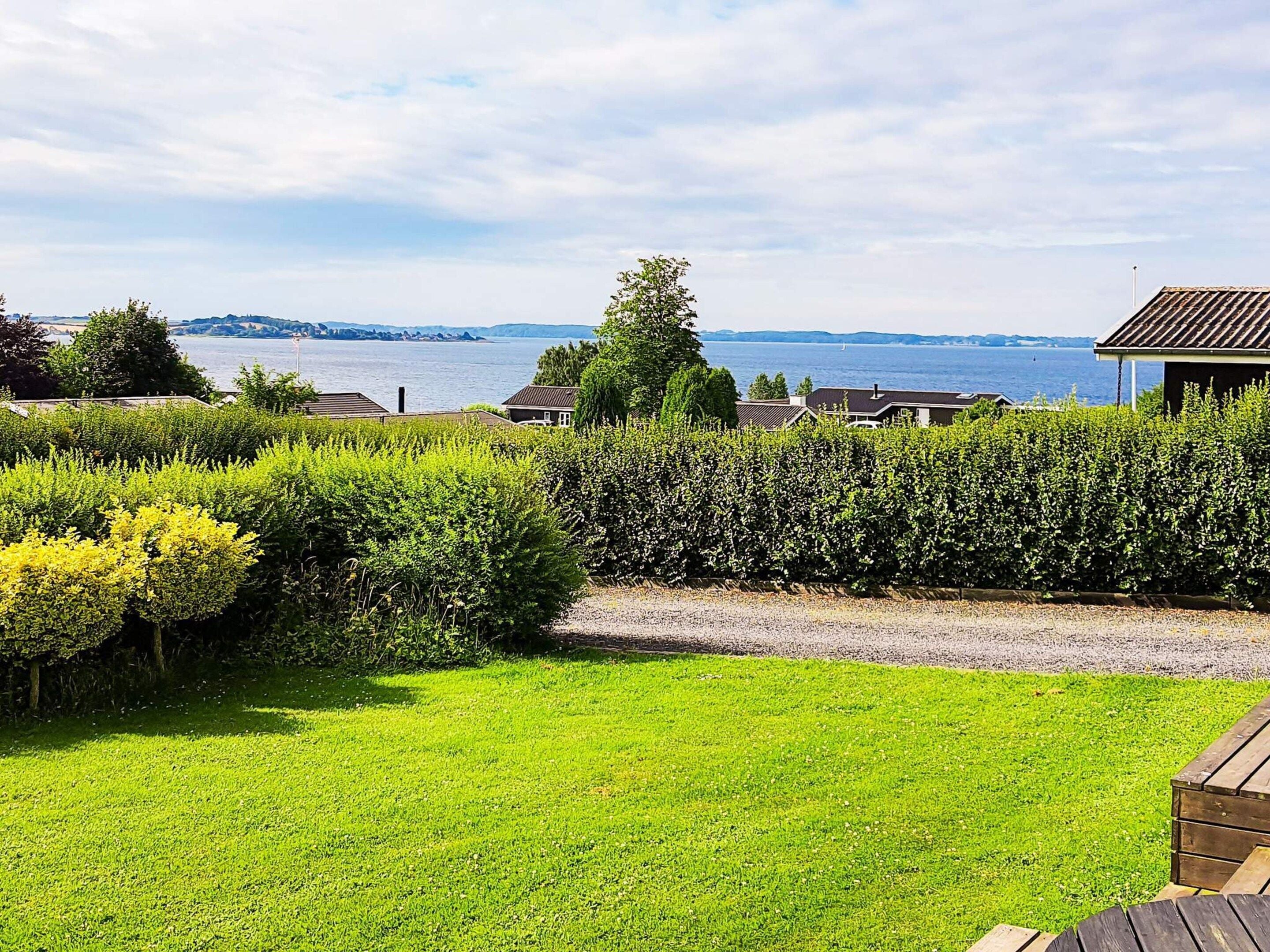 A grassy area with a view of a lake and distant hills.